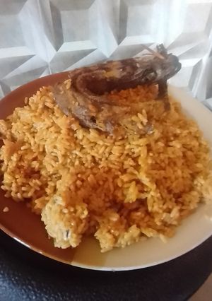 A picture of Jollof rice with fried fish.