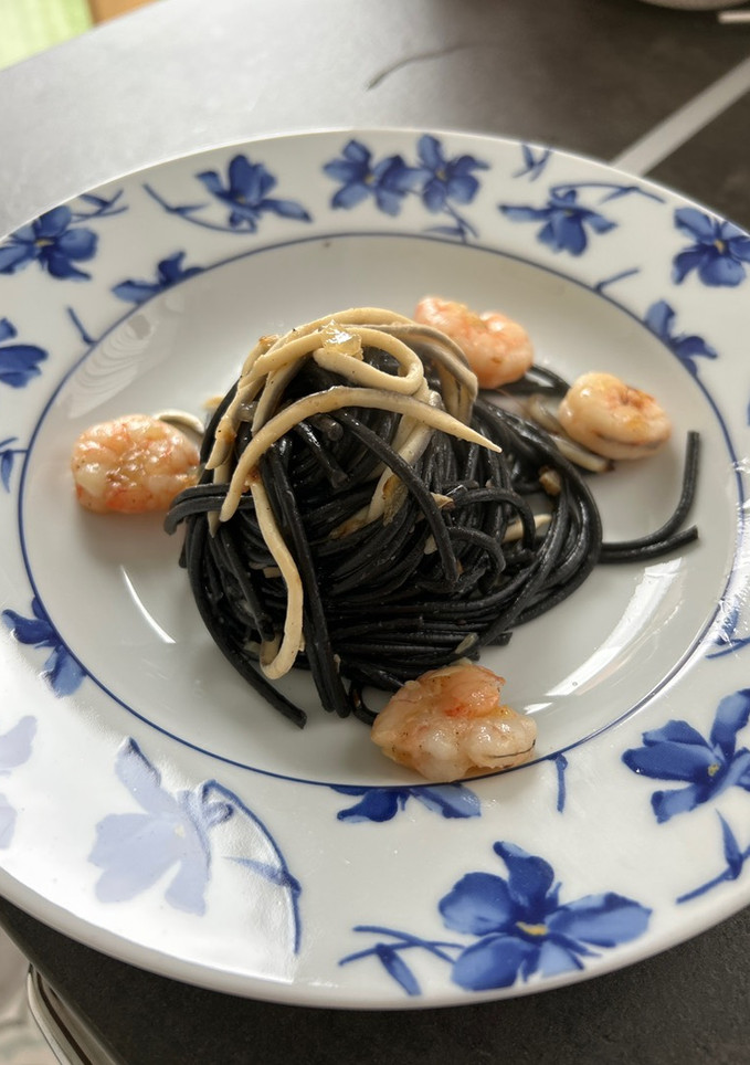 Una foto de Espagueti al nero di sepia con gulas y gambas