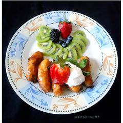 A picture of Caramelized Banana with Berries, Kiwi and Sour Cream.