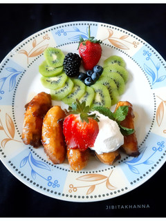 A picture of Caramelized Banana with Berries, Kiwi and Sour Cream.