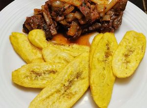 Una foto de Bistec Hígado en Achiote y Ají de Panca con Tajadas