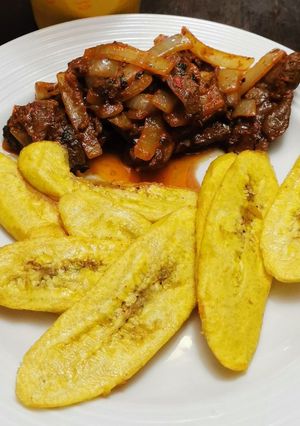 Una foto de Bistec Hígado en Achiote y Ají de Panca con Tajadas