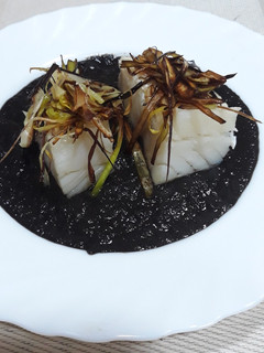 Una foto de Bacalao confitado a baja temperatura al horno con salsa de tinta
