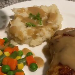 A picture of Pan fried chicken with mashed potatoes and Gravy.