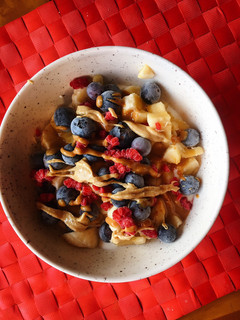 Una foto de Yogur griego con plátano, frutos rojos y cremas de frutos seco
