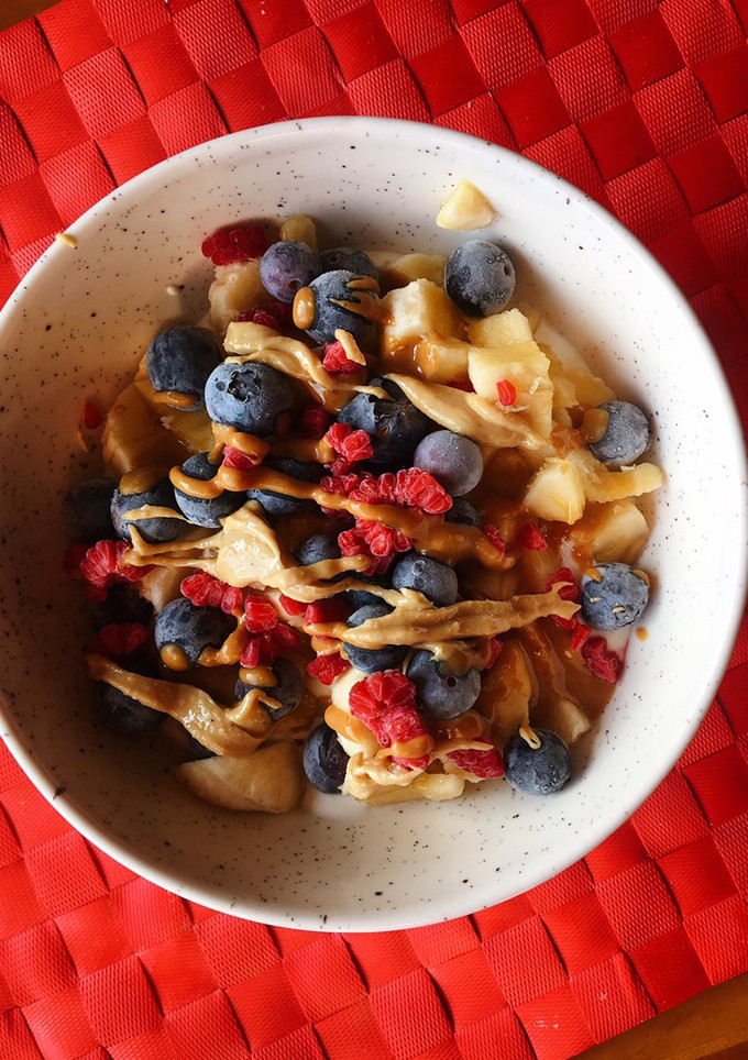 Una foto de Yogur griego con plátano, frutos rojos y cremas de frutos seco