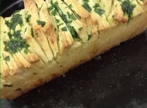 Una foto de Pan "en fetas" saborizado con queso, manteca y perejil
