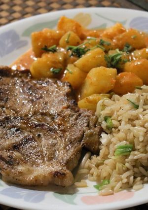 Una foto de Chuleta con papas bravas y arroz frito