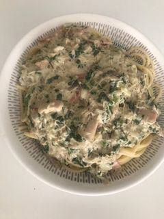 Una foto de Pasta larga con salsa blanca pollo, tocineta, ajo y espinacas