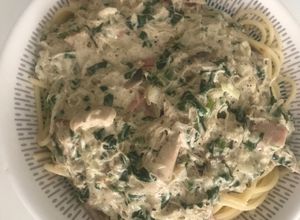 Una foto de Pasta larga con salsa blanca pollo, tocineta, ajo y espinacas