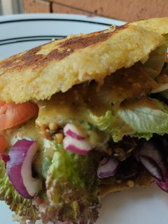 Una foto de Arepa🫓 rellena de berenjena🍆 ahumada, vegetales🧅🍅🥙 y aderezo🤔