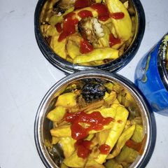 A picture of Fried potatoes and fish with ketchup.