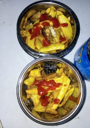 A picture of Fried potatoes and fish with ketchup.