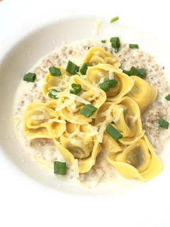 A picture of Riccota And Spinach Tortellini In Ground Pork Parmesan Sauce.