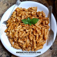 A picture of Homemade pasta with basil sauce.
