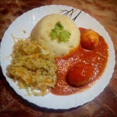 A picture of Mashed potatoes with egg curry.