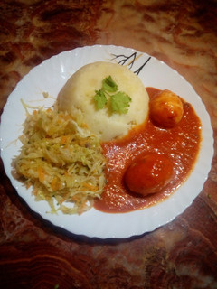 A picture of Mashed potatoes with egg curry.