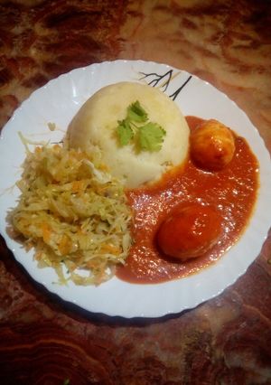 A picture of Mashed potatoes with egg curry.