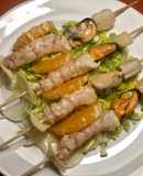 Pincho de ceviche de pescado, mejillones y gambones, sobre cama de verduras crudas y frutas