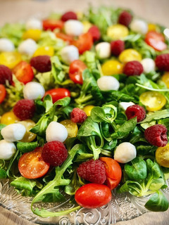 Una foto de Ensalada de tomate, frambuesas, aguacate y mozzarella con aliño especial