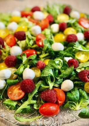Una foto de Ensalada de tomate, frambuesas, aguacate y mozzarella con aliño especial