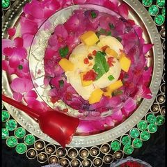 A picture of Mango tutti frutti ice cream in rose petals icebowl.