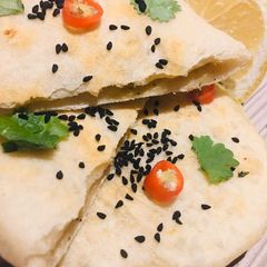A picture of Lentil Stuffed Paratha with onion seeds.