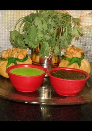A picture of Potli samosa with curd n corriander chutneys.