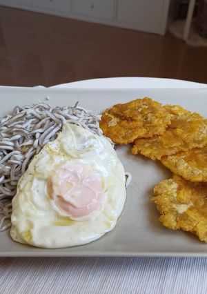 Una foto de Gulas al ajillo con huevo frito y patacones