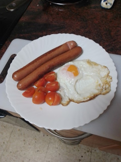 Una foto de Salchichas con huevo frito y tomate cherry