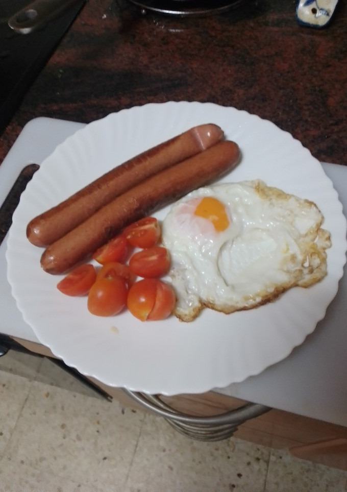 Una foto de Salchichas con huevo frito y tomate cherry