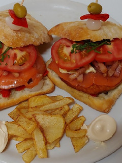 Una foto de Hamburguesa salmón ahumado y bacon a tiras con cebolla