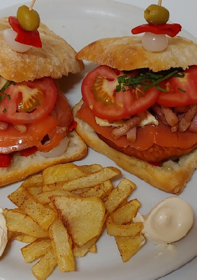 Una foto de Hamburguesa salmón ahumado y bacon a tiras con cebolla