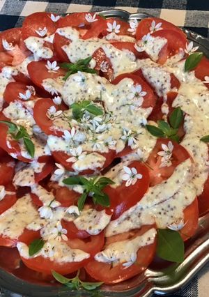 Une photo de Salade de tomates sauce crème, basilic et fleurs d ail du jardin