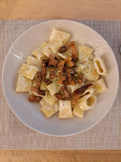 Una foto de Calamarata con salsa de burrata, pistacho y guanciale