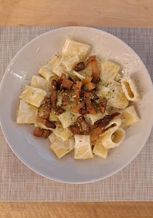 Una foto de Calamarata con salsa de burrata, pistacho y guanciale