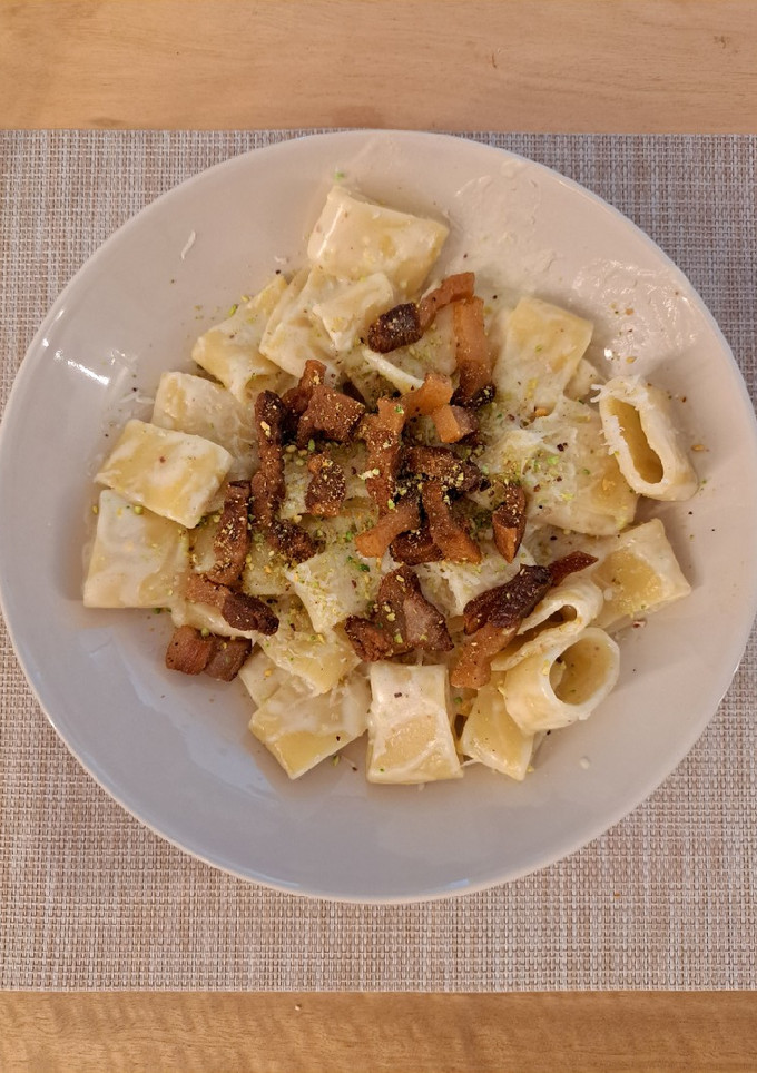 Una foto de Calamarata con salsa de burrata, pistacho y guanciale
