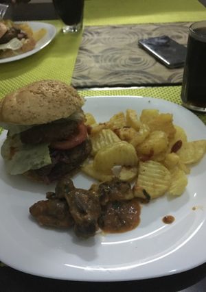 A picture of Potato wedges,wet fried gizzards and burger.