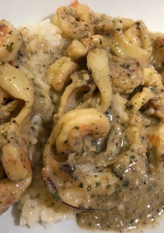 Una foto de Sepia con gambas y calamares en salsa de ajo, perejil y coco…con base de arroz blanco