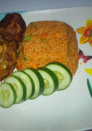 A picture of Jollof rice and Turkey with cucumber.