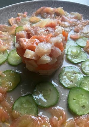 Una foto de Tapa de Carpaccio de tomate rosa y pepino con timbal de ahumados