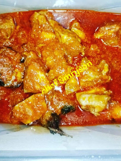 A picture of Tomato stew with chicken and fried fish.