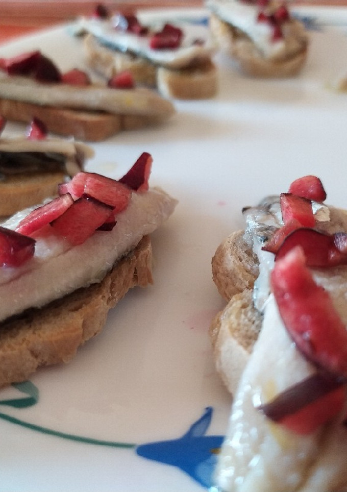 Una foto de Sardinas marinadas acompañadas de cereza y queso