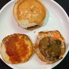 A picture of Bun sandwich with raw banana tikki and veggies.