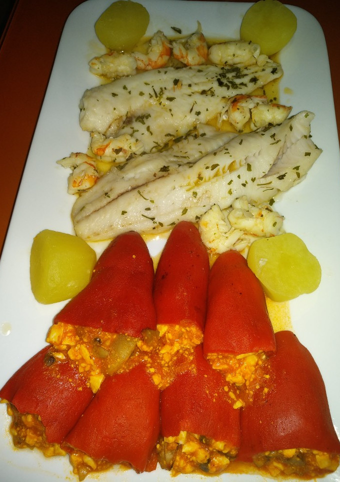 Una foto de Merluza en salsa marinera con pimientos del piquillo relleno