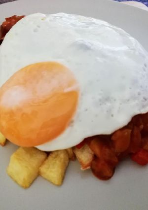 Una foto de Pisto con huevo a la plancha y patatas fritas