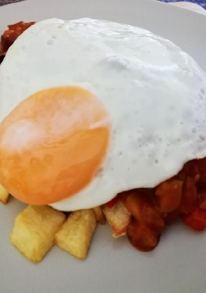 Una foto de Pisto con huevo a la plancha y patatas fritas