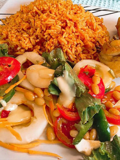 A picture of Jollof rice,fried chicken and salad.