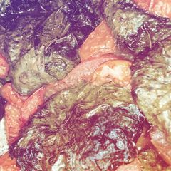 A picture of Meat wrapped in vine leaves.