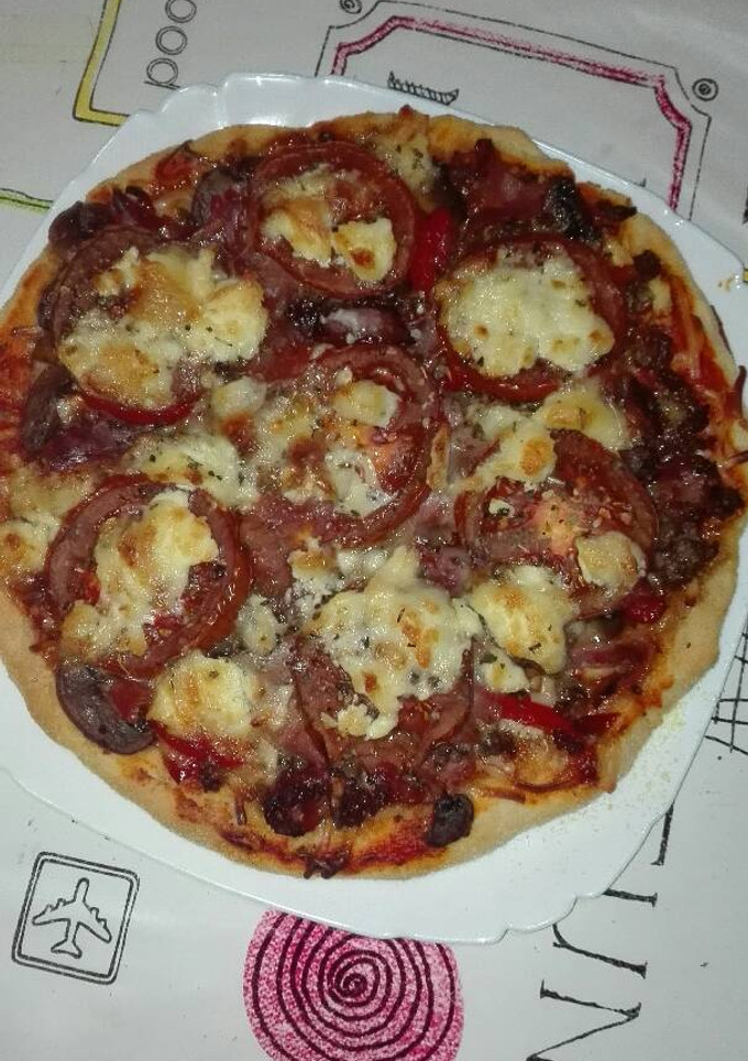 Una foto de Pizza de carne de venado champiñones, jamón y queso de rulo de cabra 